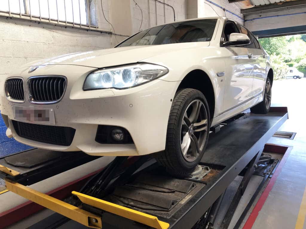 MOT test being carried out on white car